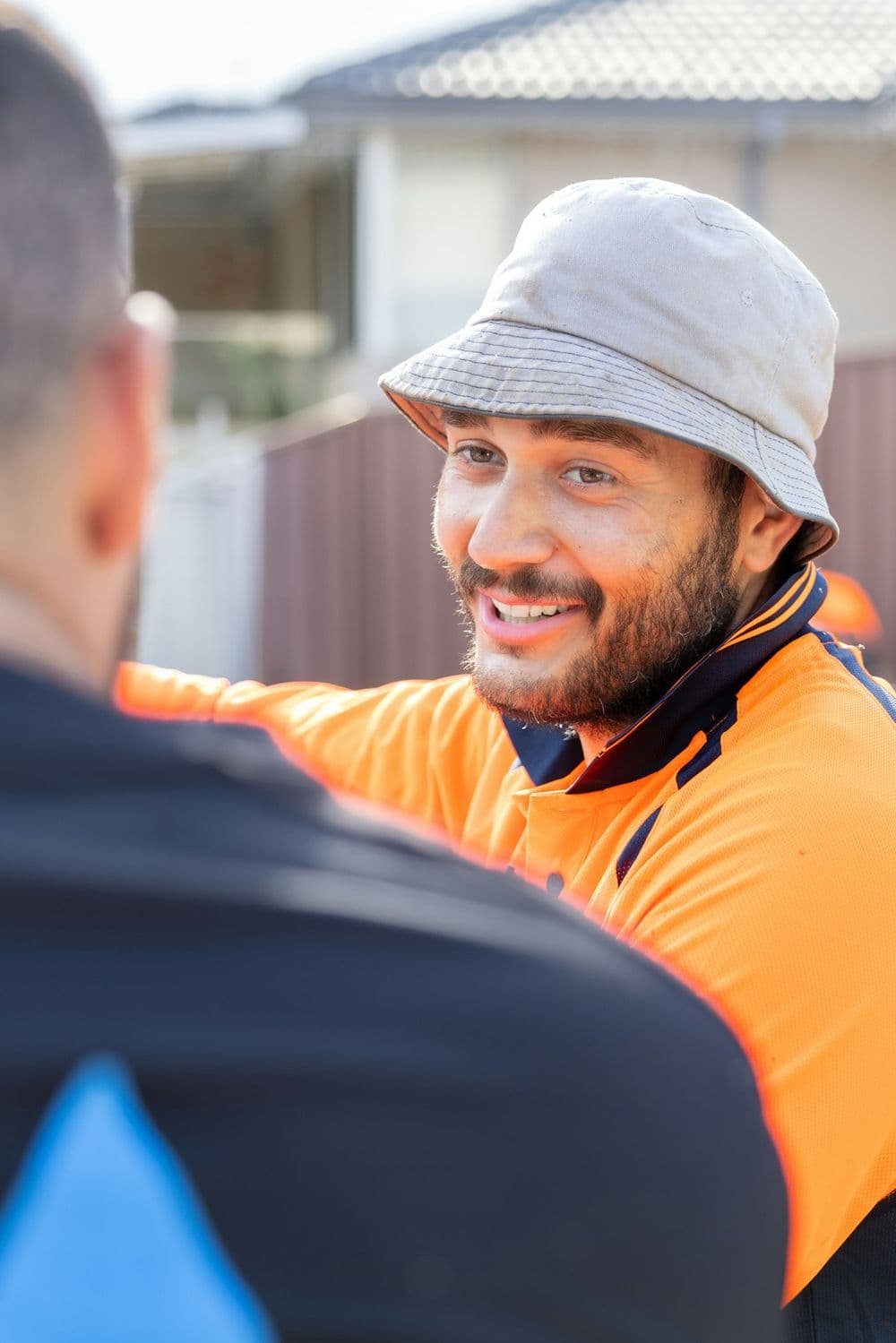 A tradesperson in hi-vis, smiling as he talks with a customer